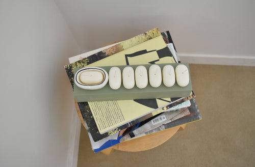 Stack of books with a phone model on top, leaning against a wall，Honey Flamingo，韓國設計品牌，天然大豆香氛蠟燭