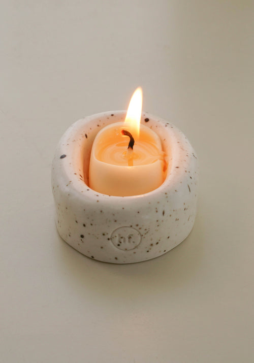 Small speckled ceramic candle holder with a lit candle on a plain background, Honey Flamingo Candle set