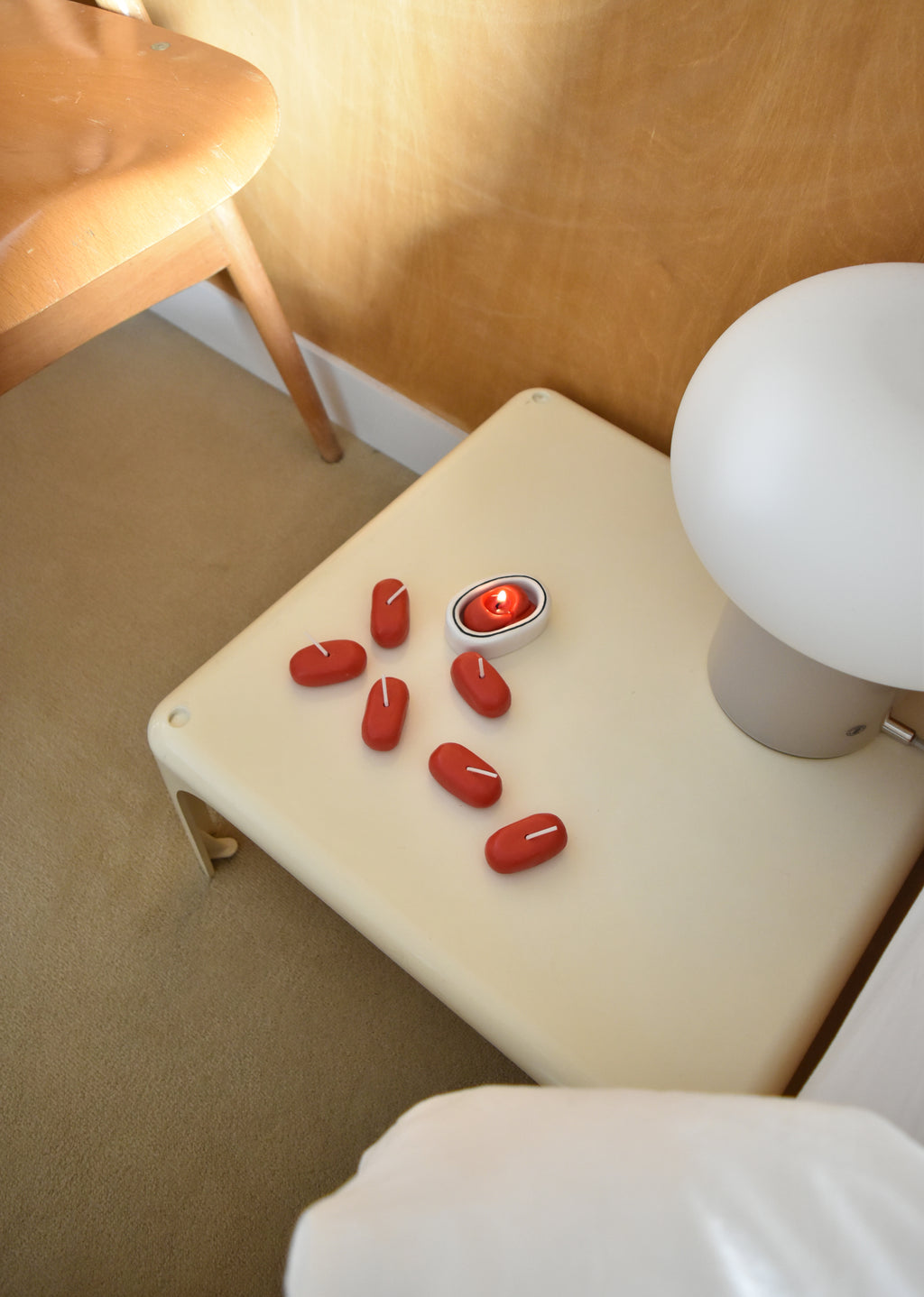 Red candies on a white surface with a lamp in the background，Honey Flamingo，韓國設計品牌，天然大豆香氛蠟燭