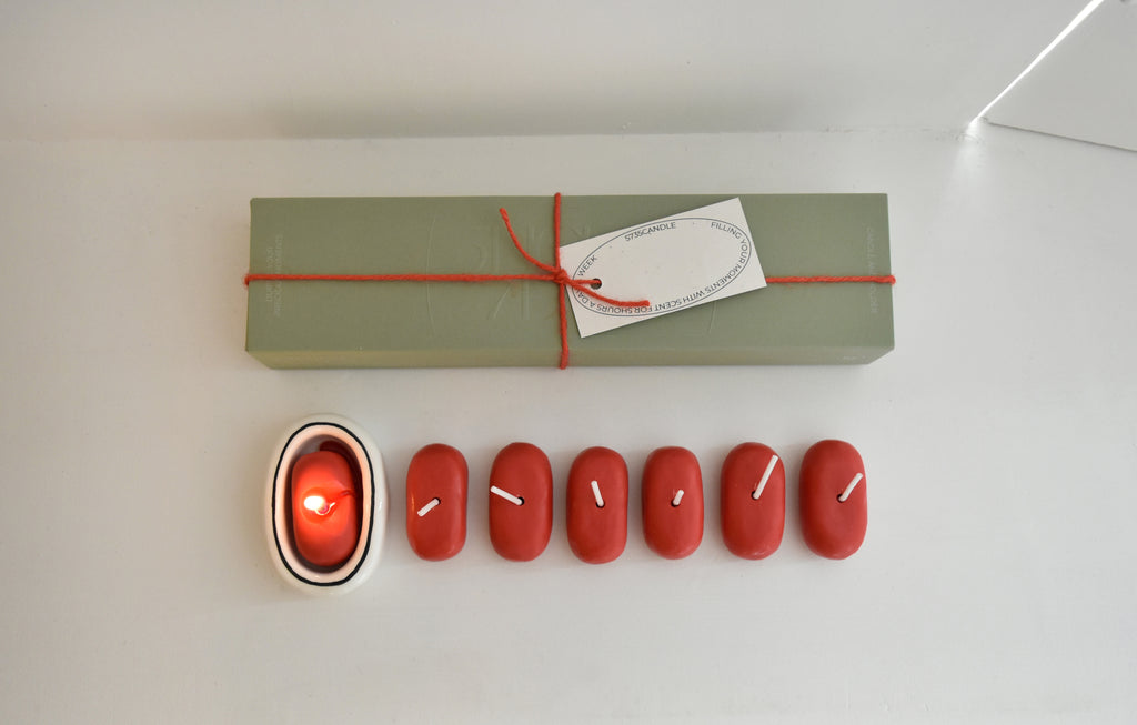 Set of red candles with a lit candle and a wrapped gift box on a white surface，Honey Flamingo，韓國設計品牌，天然大豆香氛蠟燭