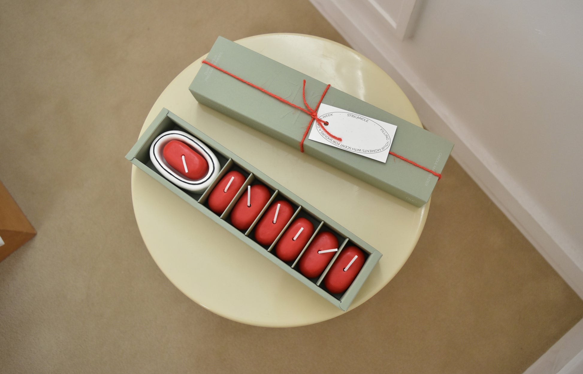 Set of red candles in a green box with a matching green lid on a beige surface，Honey Flamingo，韓國設計品牌，天然大豆香氛蠟燭