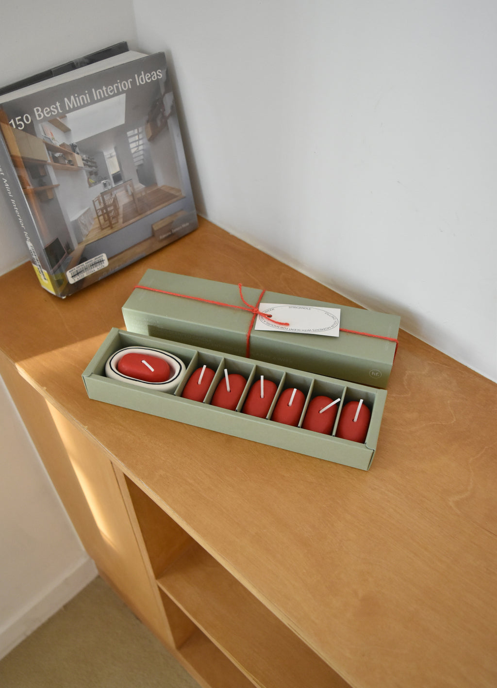 Set of red candles in a green box on a wooden surface with a book in the background，Honey Flamingo，韓國設計品牌，天然大豆香氛蠟燭