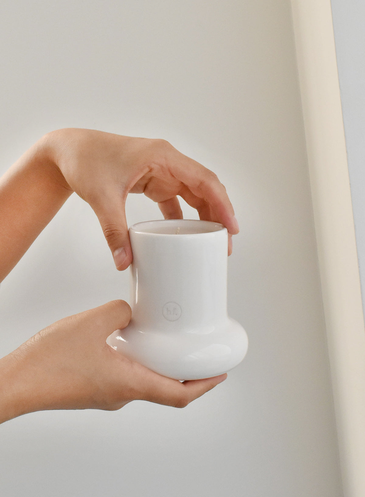 Person holding a white ceramic mug against a plain background，Honey Flamingo，韓國設計品牌，天然大豆香氛蠟燭