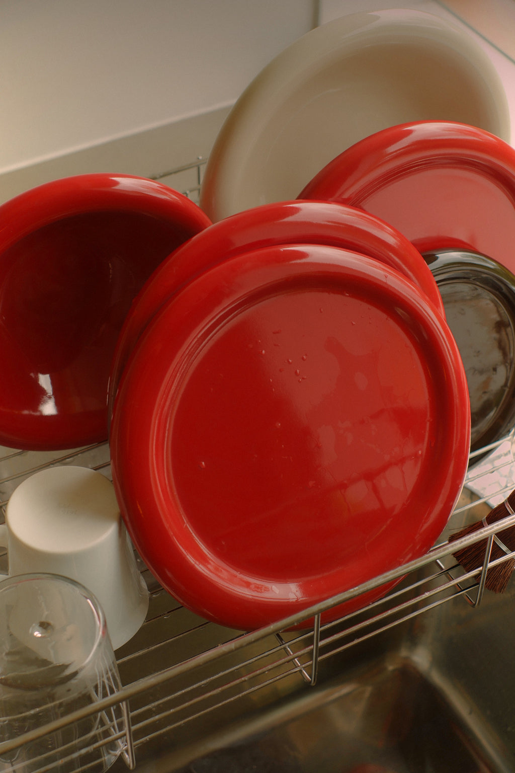 Red lids on a dish rack with a sink in the background，澳洲設計品牌，Softedge  Dinner Plate，Tomato 紅